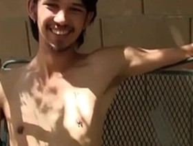 Young Asian man masturbates outdoors.