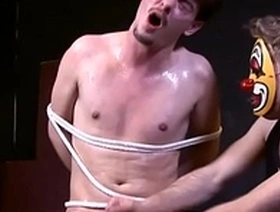 Bonded sub cums while tugged by masked dom