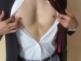 A gay Japanese man masturbates while wearing a suit.